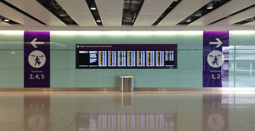 Flight information screen and directional signage at Heathrow Airport designed by Triagonal